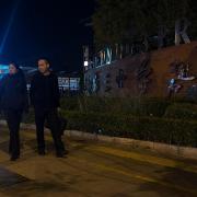 Plainclothed police pass by the Beijing primary school following the attack (Andy Wong/AP)