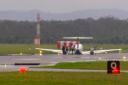In this image taken from video, passengers alight after a light plane with three people aboard landed safely without landing gear at Newcastle Airport, Australia (Channel 10 via AP)