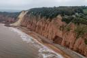 A cottage, sitting 10-metres from a cliff edge (to the right of the frame) with a 400ft drop, following a rockfall (seen as the light area to the left of the frame some distance away) on a cliff top area between Sidmouth and Ladram Bay. Picture date: