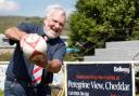 Cheddar Valley RFC President John Bayliss in front of the new Bellway signage