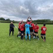 The Weston Town squad celebrate after confirming their league win