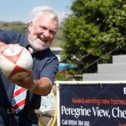 Cheddar Valley RFC President John Bayliss in front of the new Bellway signage